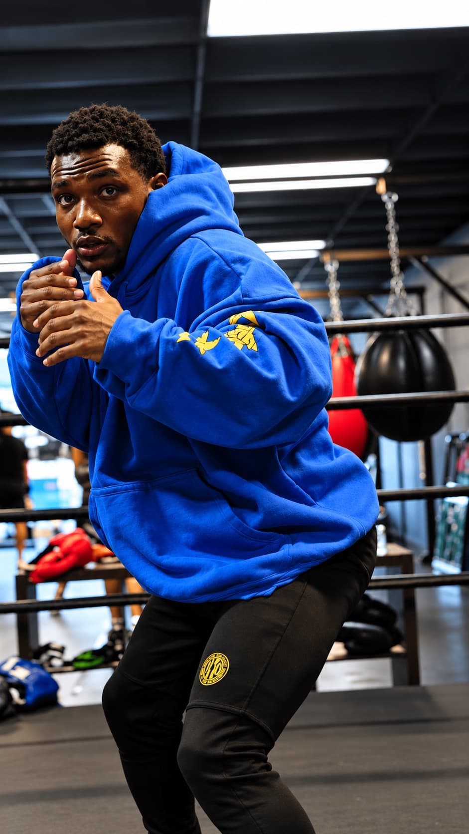 Kenneth Sene shadowboxing in a blue hoodie